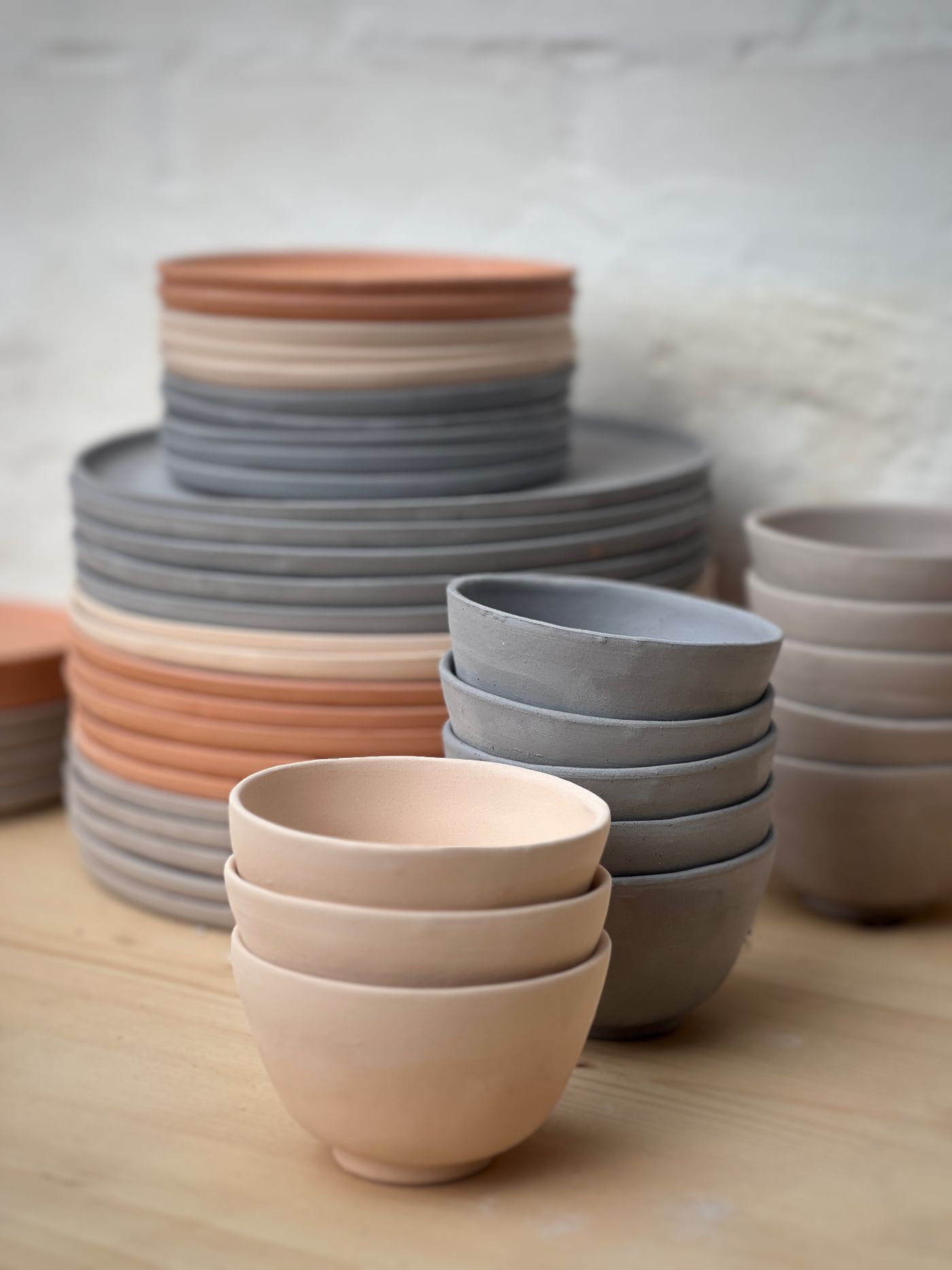 Stacks of handmade ceramic bowls and plates