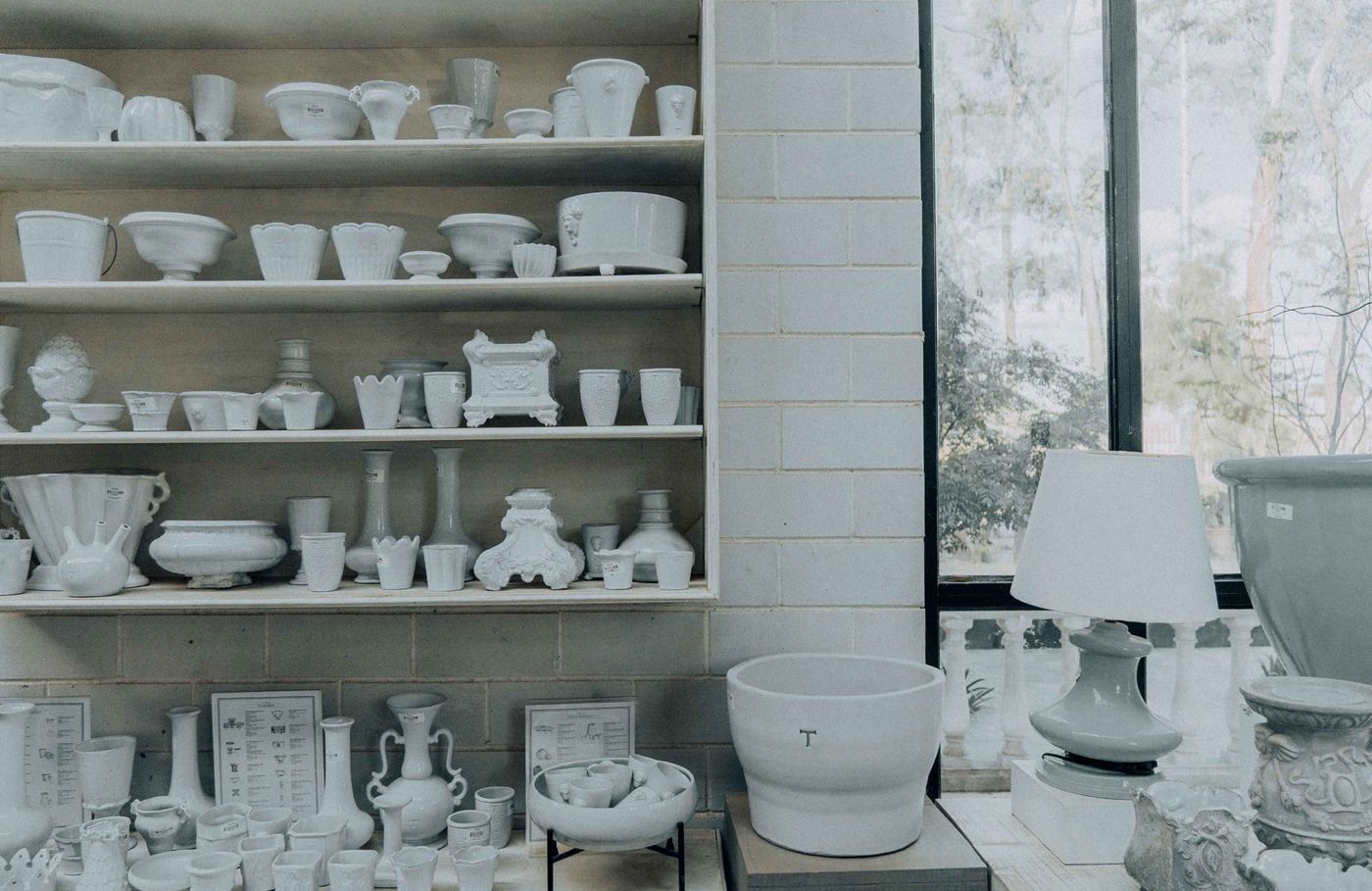 Shelves of handmade bowls, mugs, and vessels in a ceramics studio