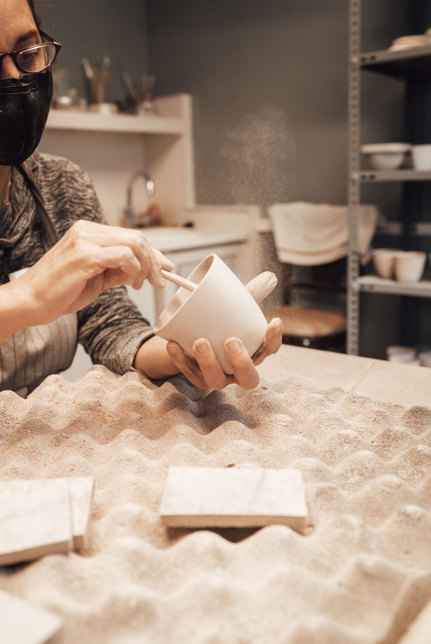 An artisan painting a ceramic mug by hand