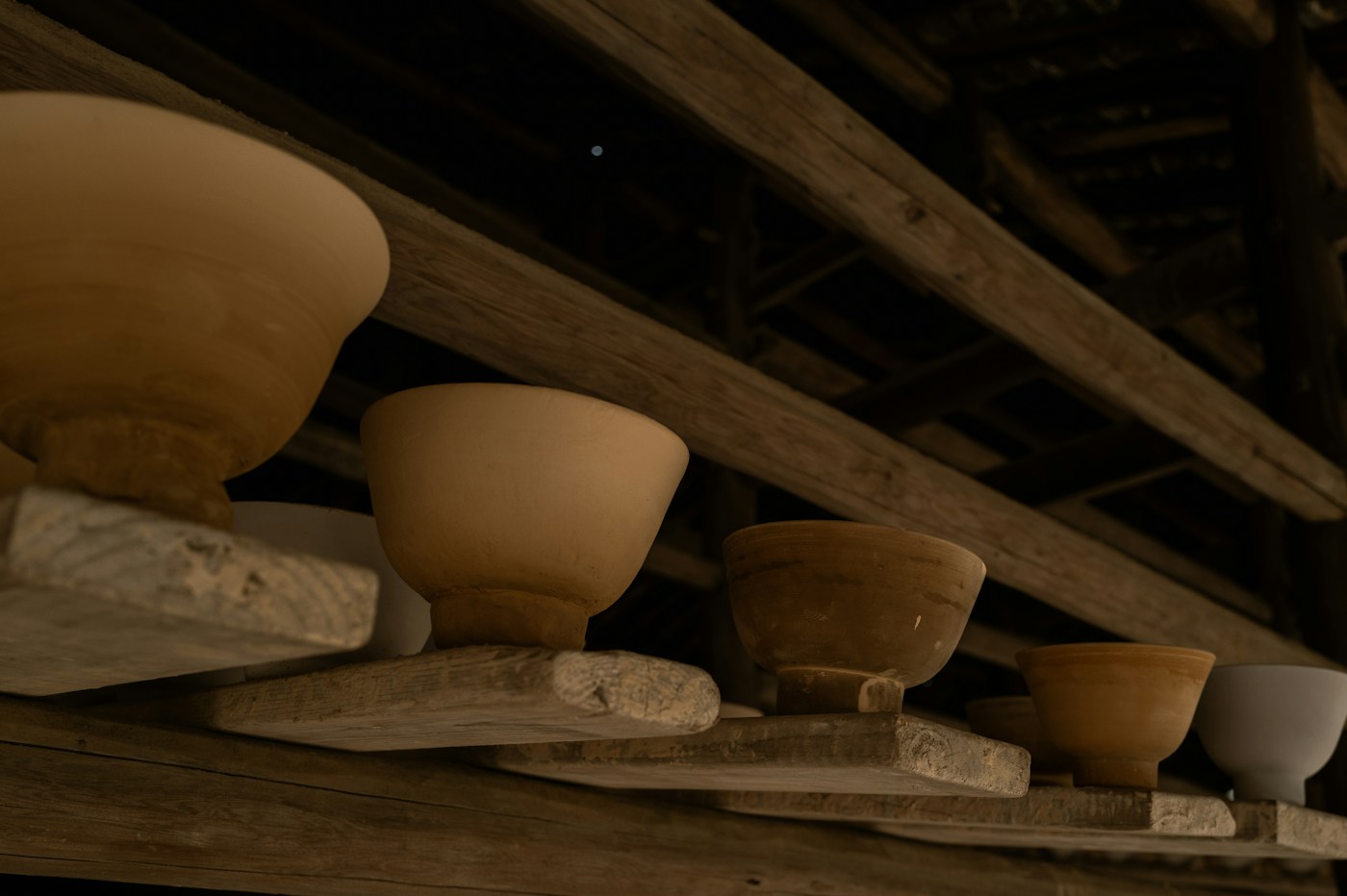 Ceramic bowls and vessels arranged on studio shelves
