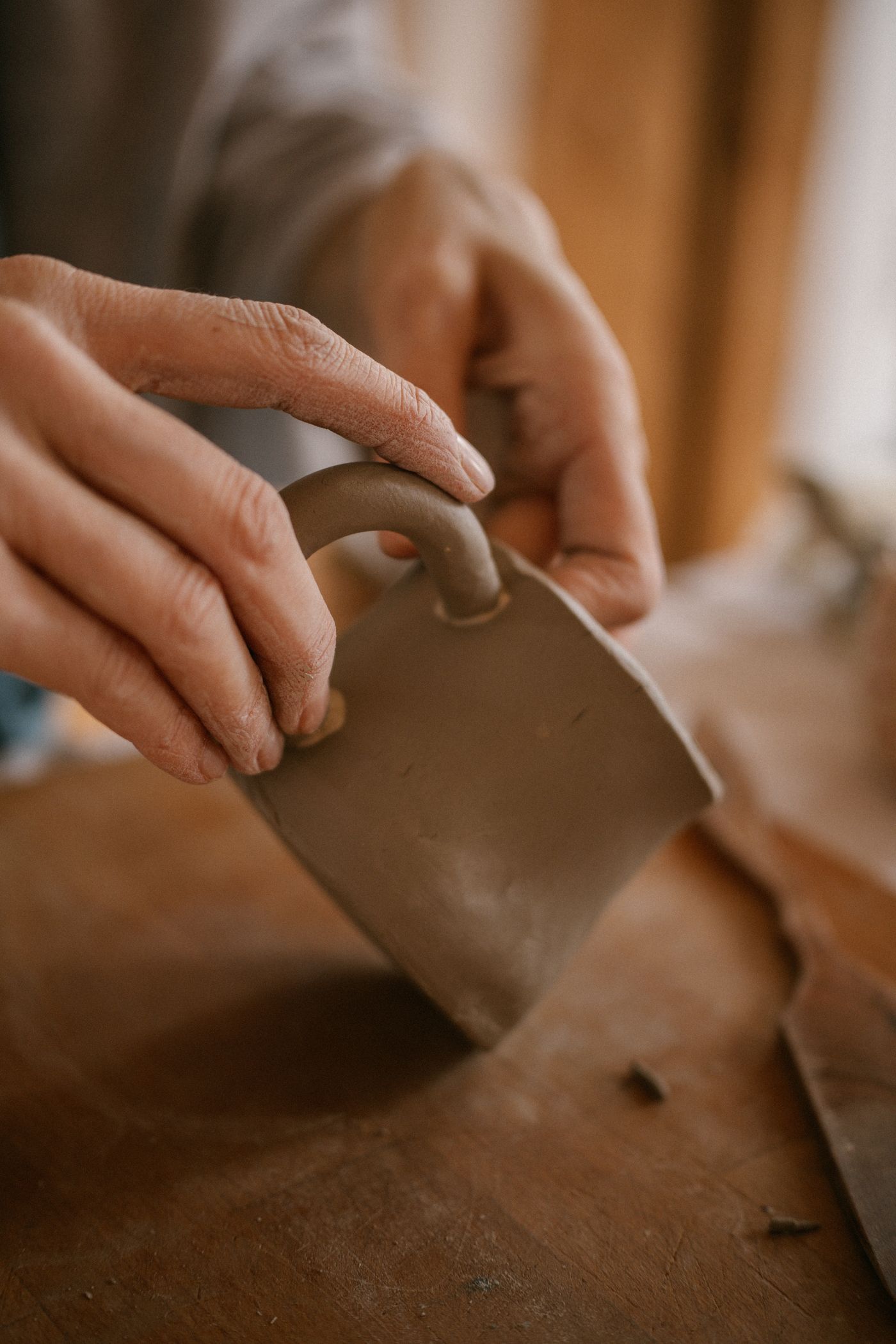 A ceramic mug taking shape under the maker's hands
